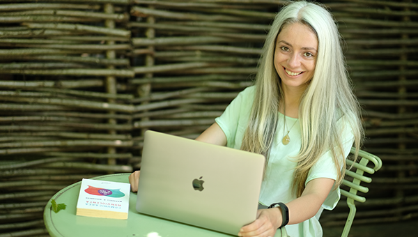 Anca Zlavog sta la masa in fata unui laptop